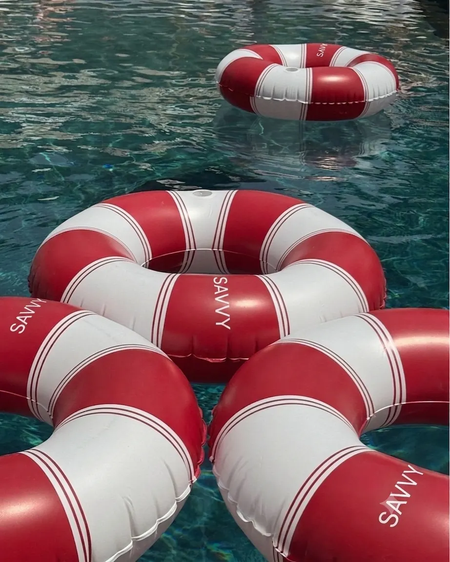 Savvy Swim red and white ring buoys floating in a pool